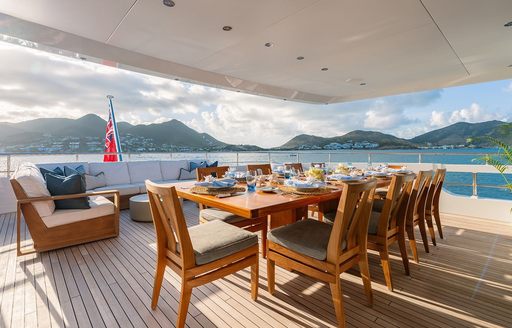 Exteriors onboard charter yacht MOSKITO with long table surrounded by wooden seating