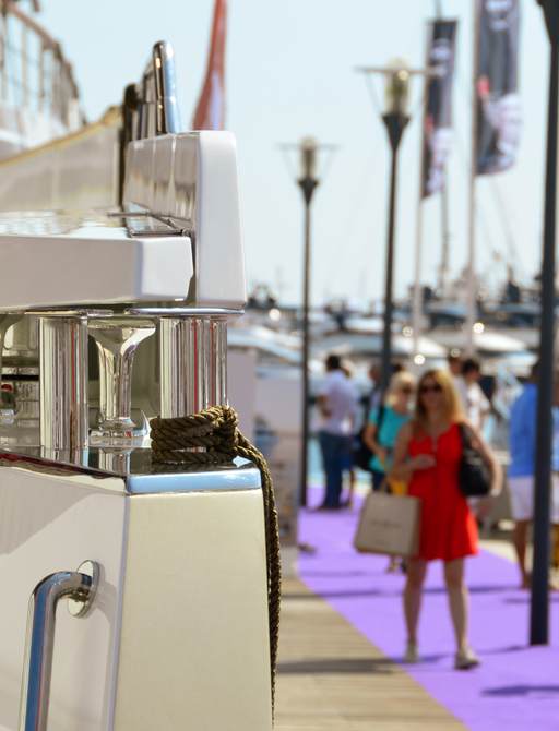 Woman walks down the boardwalk alongside yachts at Cannes Yachting Festival