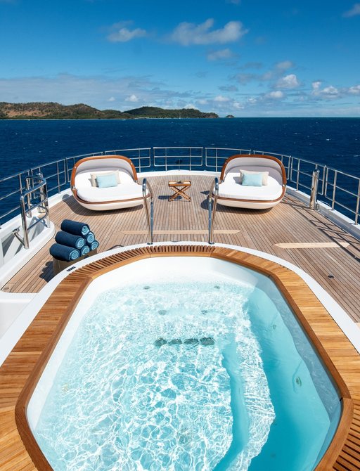 Aerial view of spa pool on superyacht DRIFTWOOD with oyster sun pads on sun deck beyond