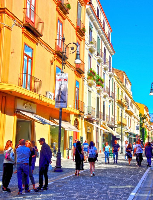 Beautiful colored town houses overlooking a cobbled thoroughfare in Naples, Italy